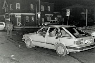 West-end killing: Blood is evident on the driver's door of this Nissanin which an unidentified man was found shot to death on Vaughan Rd