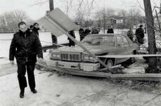 Death car: Police set up barriers around a crashed getaway car after a robber killed his accomplice and himself after a botched heist