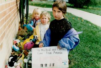 In Remembrance: Kayla Boudreau, 5, left, Amy Richardson, 4, and her big sister Amanda, 8, put cards at the townhouse where their friends died