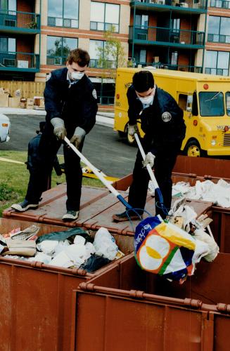 Not a trace: Police sift through dumpsters yesterday at the Coatsworth Crescent complex where Andrea Atkinson, 6, vanished Sunday