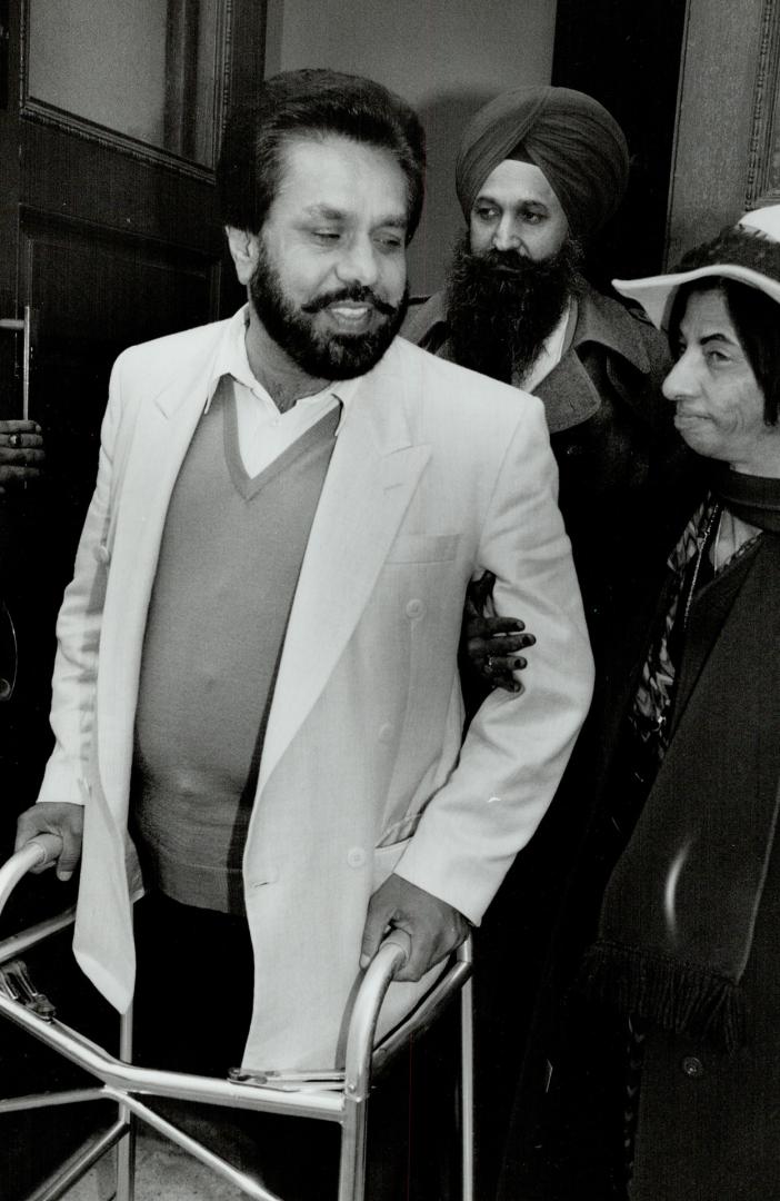 Partially paralyzed: Witness Amarjit Singh Tatla, wounded in 1982 shooting, is helped yesterday by Esauro Lopez Fonseca, sister of lawyer killed in the incident