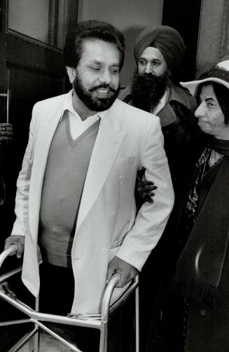 Partially paralyzed: Witness Amarjit Singh Tatla, wounded in 1982 shooting, is helped yesterday by Esauro Lopez Fonseca, sister of lawyer killed in the incident