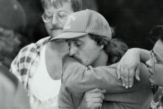 Helping hands: Friends console Kayla's father, Steve Klaudusz, as he takes a break in his search near the Humber River yesterday
