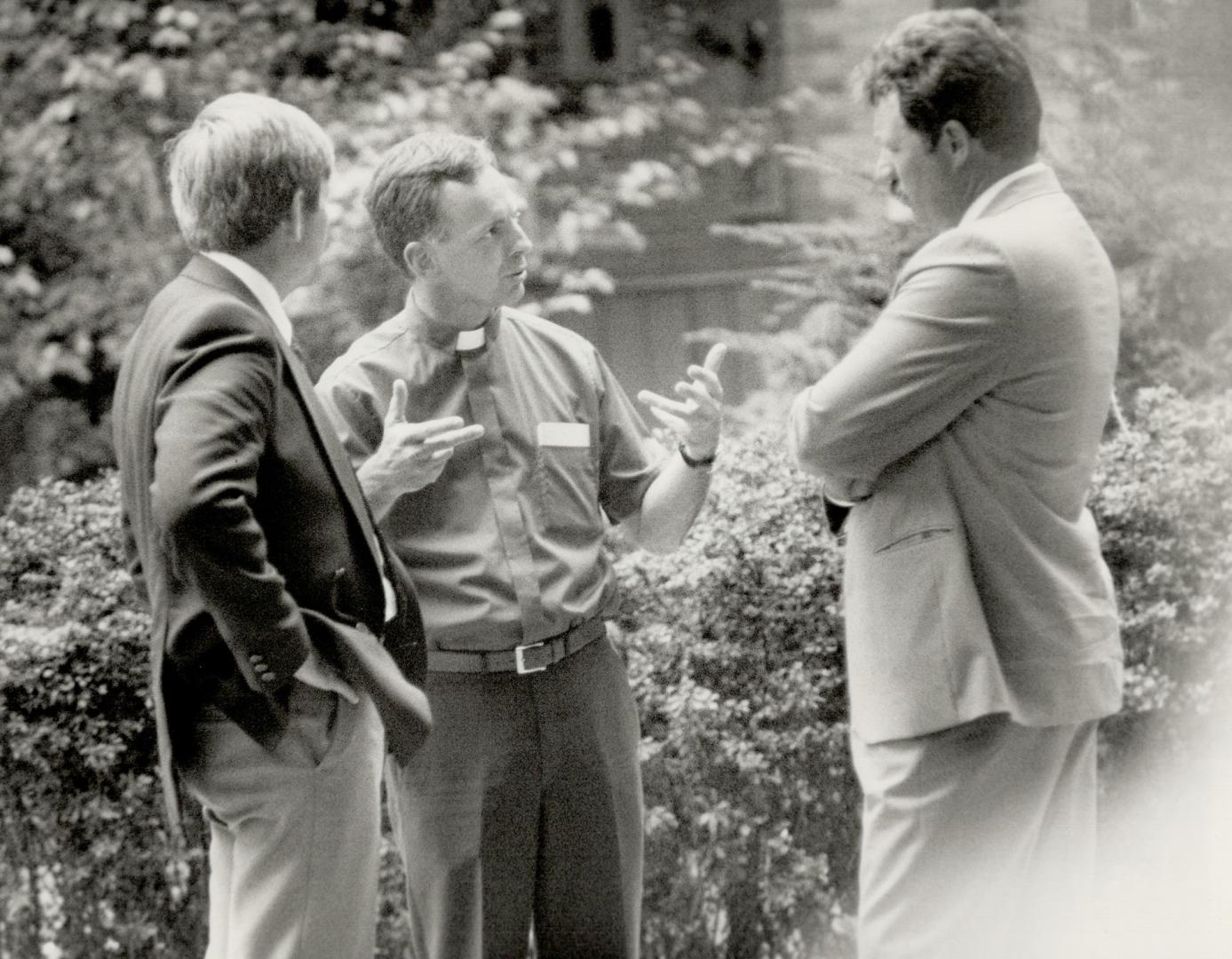 In discussion: Rev. Carl Sulliman, a friend of the Parrott family, talks with two Metro police officers yesterday outside the family's home on Summerhill Ave