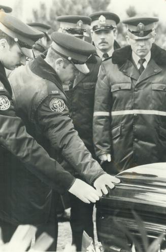 The last goodby: Fellow police officers touch Constable Michael Sweet's casket in tribute following funeral services