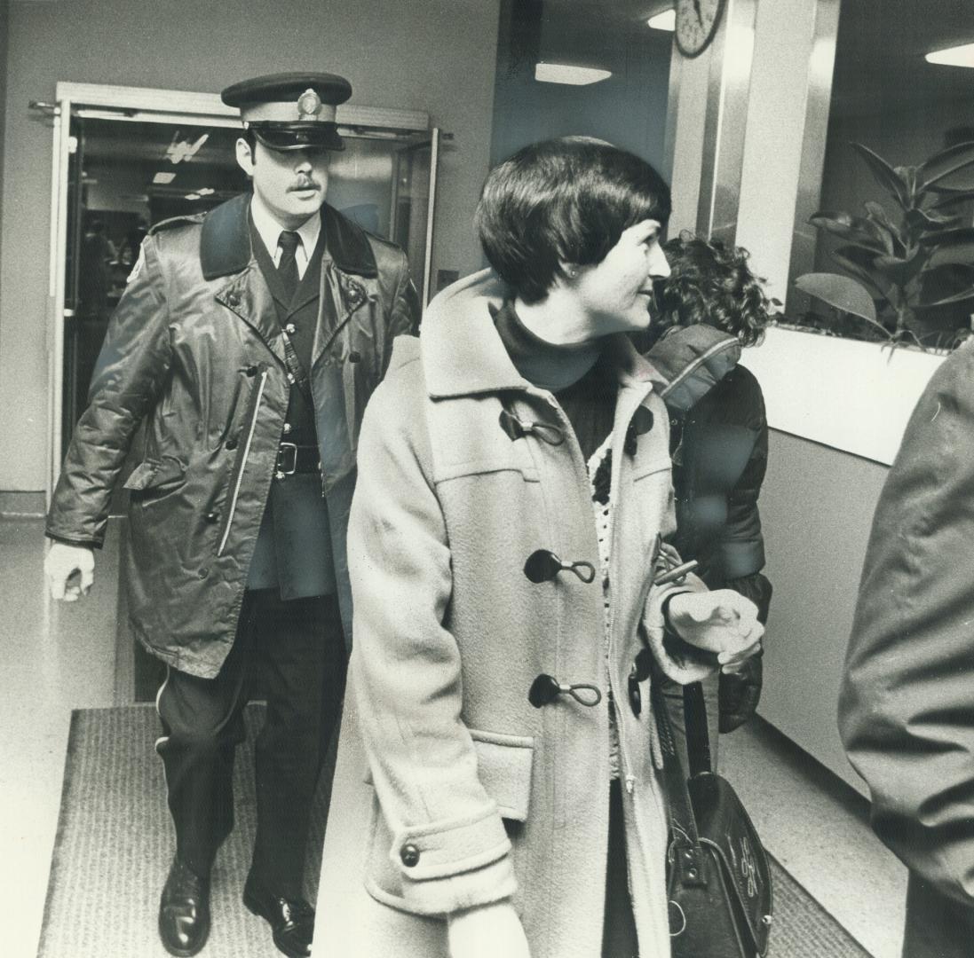 Wife of wounded Brink's messenger Evelyn Chambers, leaves Toronto East General Hospital with youngest son, Trevor (right), 13, after visiting husband,(...)
