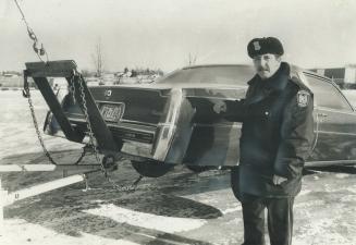 Death car. Peel Constable John Fox with the Cadillac in the trunk of which the frozen body of salesman Edward Neuff, 33, of Gothic Ave. was found