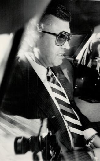 Colin Thatcher on his way from prison to court house where he took stand for first time since trail start in this exiting city. He is in R.C.M.P. cruiser