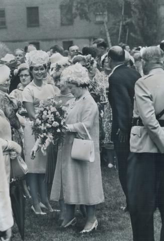 Roses between the raindrops, Queen Mother charmed off the rain long enough for the Black Watch to go ahead with its scheduled garden party yesterday o(...)