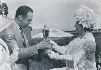 Queen's Plate trophy for winning colt Whistling Sea was presented to Calgary owner Paul Olivier by the Queen Mother Saturday, as Mrs. Olivier, at extr(...)