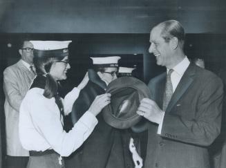 It may look like a tug-of-war, but it's just Dianne Murray returning Prince Philip's hat to him after a rally of Venturer Scouts in the Scarborough Ce(...)
