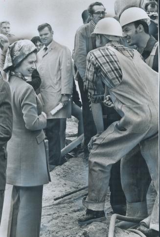 Wearing a pantsuit as protection against blackflies, Queen Elizabeth talks with a group of miners during a pause in drilling competition at Yellowknif(...)