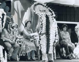 An Indian Chief is presented to the Queen yesterday in Thunder Bay. She shook hands with five chiefs; including 86-year-old Frank Pelletier. His grandson, Chief Leonard Pelletier, gave the Queen a beaded stole; in behalf of nine bands who came under the Robinson Superior Treaty; and his crippled granddaughter; 8-year-old Trina Pelletier; gave the Queen bouquet of roses and carnations from her wheelchair.