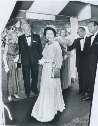 Formal Gown with soft, full sleeves which Queen Elizabeth wore to a reception at Leonard Hall, Queen's University, Kingston, gives her a feminine, gracious look