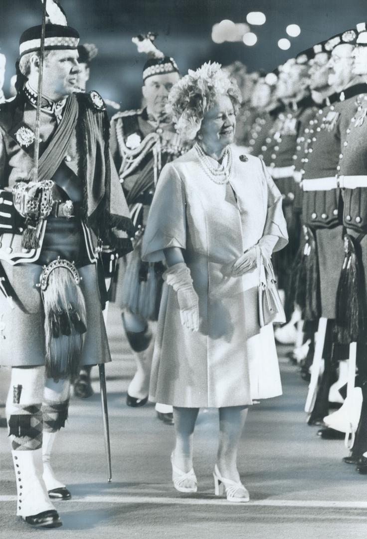 Inspecting her regiment, Queen Mother Elizabeth checks the military bearing of the Toronto Scottish Regiment at the Canadian National Exhibition groun(...)