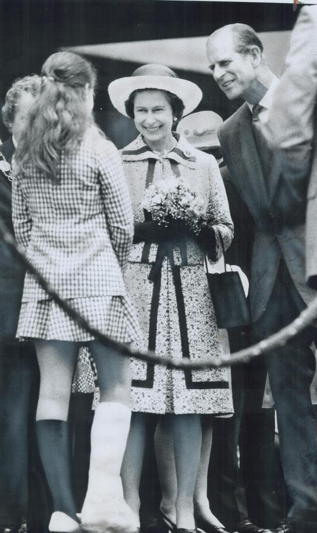 Mayor David Crombie's daughter Carrie, 11, wearing cast on her leg, presents a bouquet of flowers to the Queen today at Nathan Phillips Square at City(...)