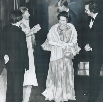 The Queen and Prince Philip return to Parliament after opening to attend dinner given by Speakers of the House and Senate. She wears a flame-colored gown with a white fur stole, and a diamond tiara