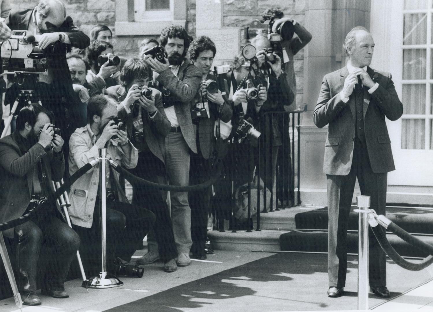 Dropping hints? Prime Minister Pierre Trudeau adjusts his tie outside 24 Sussex Dr., the official Ottawa residence of Canada's leader, just before goi(...)