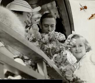 This shy, but proud and happy, fair-haired little girl was lifted high in the air to present a bouquet to the Queen