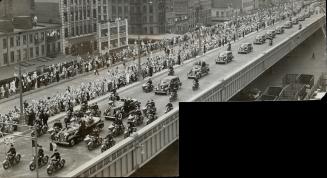 Surronded by a score of motorcycle officers, the car carrying their majesties, heads the long cavalcade from New York's Battery to the World's Fair, a(...)
