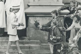 Diana receives flowers from a couple of the 2,500 well-wishers who jammed the streets and sidewalks around St