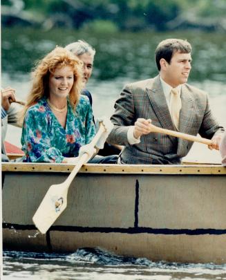 Pulling together: White-gloved Duchess of York joins Prince Andrew in propelling simulated birchbark canoe yesterday at Old Fort William in Thunder Bay