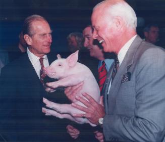Tickled pink: This little piggy, held by Royal Winter Fair president Hartland MacDougall, got an audience with Prince Philip yesterday at the fair, now running at Exhibition Place