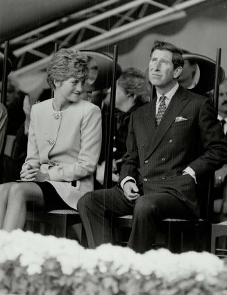 On stage: Prince Charles gazes at the lowering clouds at Nathan Phillips Square yesterday as Diana smiles at the other dignitaries