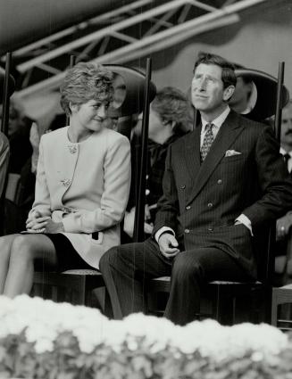 On stage: Prince Charles gazes at the lowering clouds at Nathan Phillips Square yesterday as Diana smiles at the other dignitaries