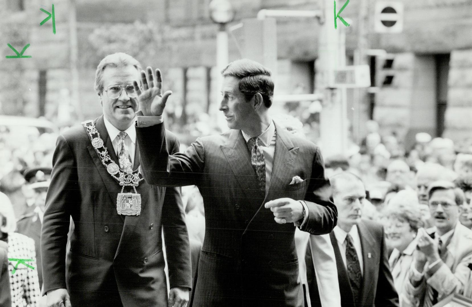 Toronto Mayor Art Eggleton follows as Prince Charles waves to crowd in Nathan Phillips Square today