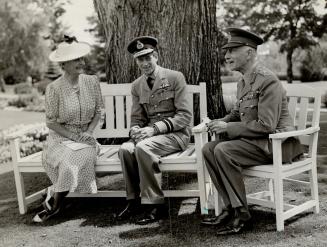 Relaxing after the longest flight he has yet had, the Duke of Kent chats with the Earl of Arhlone and Princess Alice in the garden at Rideau Hall, Ott(...)