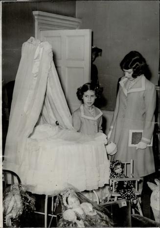 Princesses view their own cot at exhibition