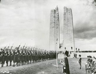 Sailors reviewed before memorial--With the huge pylons of Canada's great memorial at Vimy towering in the background