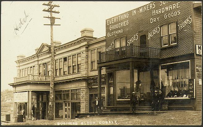 Black and white photograph of a theater with a store beside it.