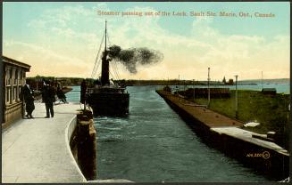 A large boat surmounted by a black cloud moves away from the camera, out the locks and into the…