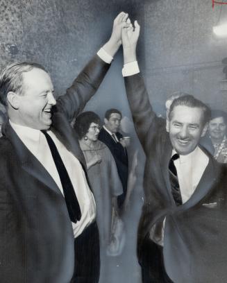 A NDP victory in Broadview riding has James Renwick (left), MPP for Riverdale, holding aloft arm of lawyer John Gilbert who beat Liberal Bob Sutherland