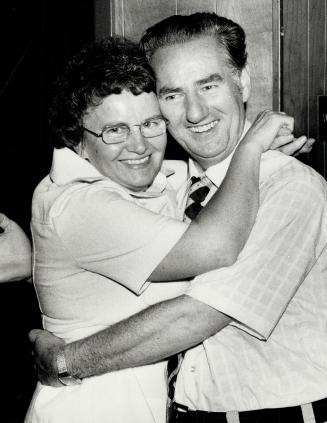 Mrs Nora Gilbert puts her arms around her husband John Gilbert, the NDP MP for Broadview, who retained his seat in the House of Commons