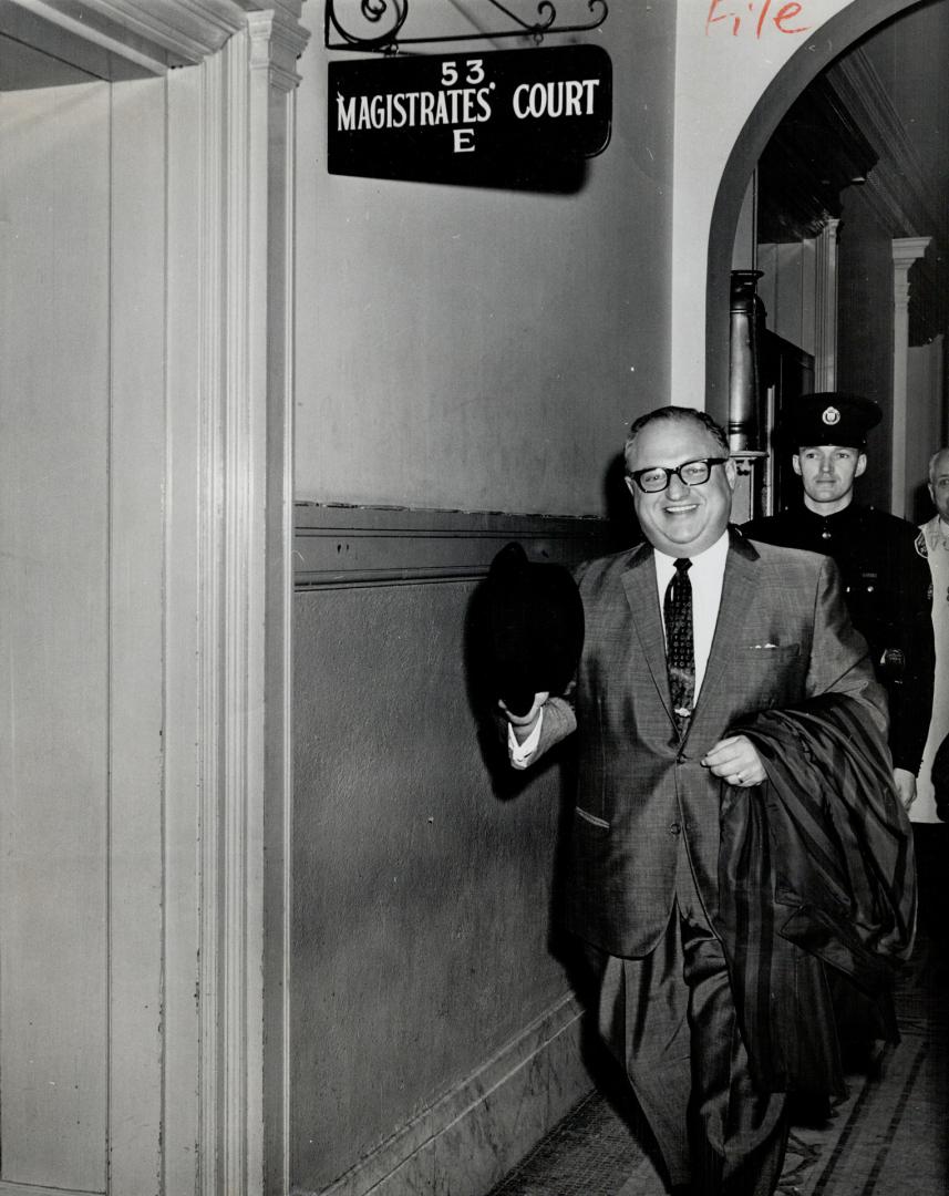 Mayor Philip Givens smiles happily as he arrives under the sign of Courtroom D to testify in the hearing of John Beattie re. Allan Gardens disturbance