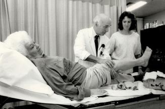 Treating seniors: Dr. Charles Godfrey and kinesiologist Heather Hattin, right, examine a knee injury suffered by Eleanor Beecroft, 81, at Godfrey's ne(...)