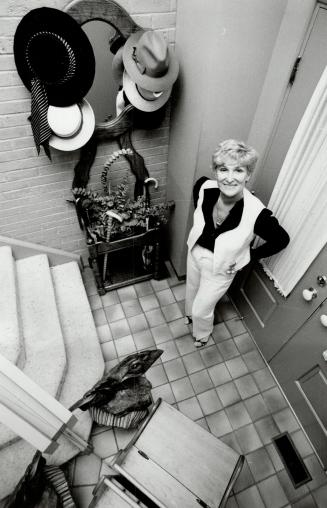 Warm atmosphere: Above, Lynne Gordon in entrance to her four-level townhouse, with old-fashioned hat rack, honey-colored walls