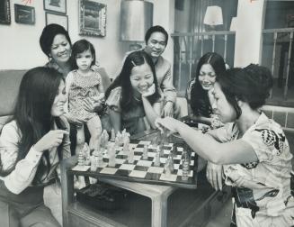 Family reunited at home of Nhi Gould, wife of CTV vice-president Tom Gould, are her two sisters and their families who fled Saigon. Holding Mrs. Gould(...)