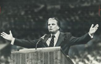 Evangelist Billy Graham, showing little sign of his 59 years, tells Maple Leaf Gardens crowd yesterday that science is on verge of proving there is a (...)