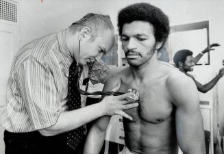 Clyde Gray of Toronto, Canadian and Commonwealth welterweight champion, is being checked by a doctor at the weigh-in for his non-title bout tomorrow n(...)