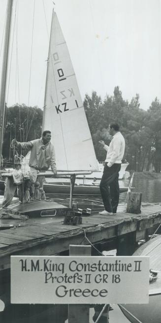 King Constantine of Greece (right) and Toronto's Phil Phelan, competing in world Dragon sailing championships, discuss tactics at basin where craft is anchored