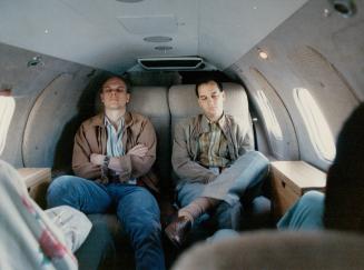Greig, left, and his assistant Dr. Dario Del Rizzo take a short nap on the 35-minute return flight from Ottawa to Toronto