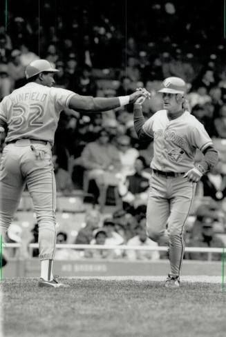 Solo shot: Kelly Gruber gets high-fived by Dave Winfield after clubbing a bases-empty homer in the first inning of Jays' 3-1 win in Detroit