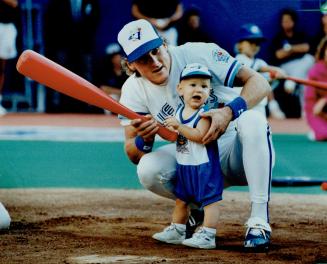 Blue Jays' third baseman Kelly Gruber gives his 1-year-old son, Kody, a few hints on batting yesterday at the SkyDome, during a pre-game event for the(...)