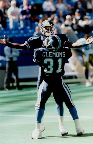 Buoyant boatmen: Mike Clemons gives Tracy Ham a hug after the Argos quarterback connected with Robert Clark for a 64-yard TD against the Bombers