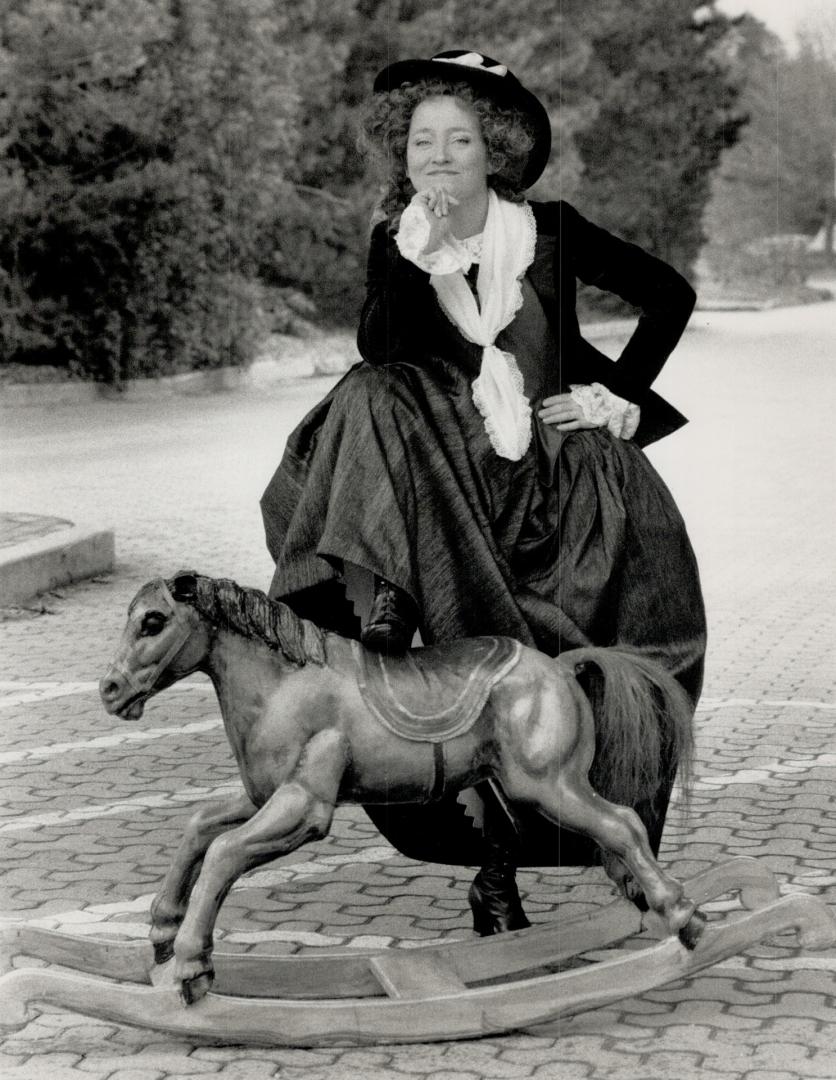 Actress Mary Haney poses in period garb with a turn-of-the-century hobby horse
