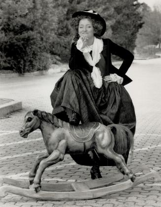 Actress Mary Haney poses in period garb with a turn-of-the-century hobby horse